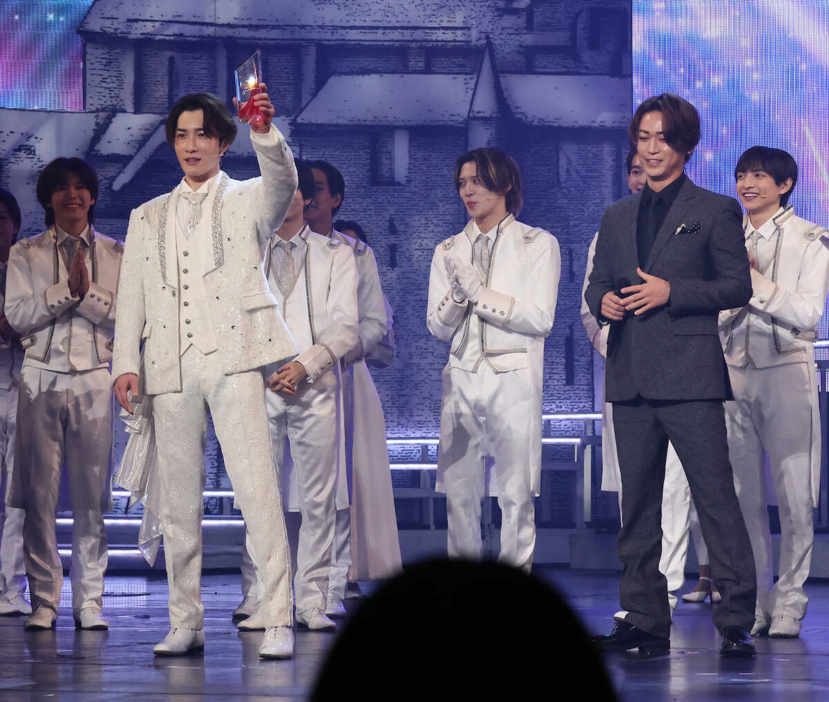 Shota Watanabe (second from left) smiling as he receives a trophy from Kazuya Kamenashi (Photo by Kentaro Nishiumi)